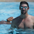 Former U.S. Olympic swimmer Michael Phelps stands in the pool as he watches kids train at the Rocinha slum sports complexin Rio de Janeiro, Brazil, Monday, March 11, 2013. Phelps is in Rio to attend The Laureus World Sports Awards ceremony. (AP Photo/Felipe Dana)