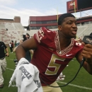 Videographer in tow, Florida State quarterback Jameis Winston (5) searches for teammates to interview during their NCAA college football media day on Sunday, Aug. 10, 2014, in Tallahassee, Fla. (AP Photo/Phil Sears)