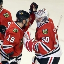 Chicago Blackhawks goalie Corey Crawford, right, celebrates with Jonathan Toews after the Blackhawks defeated the Minnesota Wild 5-1 in Game 5 of an NHL hockey Stanley Cup first-round playoff series in Chicago, Thursday, May 9, 2013.  (AP Photo/Nam Y. Huh)