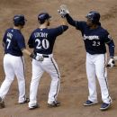 Milwaukee Brewers' Jonathan Lucroy (20) is congratulated by Norichika Aoki (7) and Rickie Weeks (23) after Lucroy hit a two-run home run during the second inning of a baseball game against the San Francisco Giants, Wednesday, May 23, 2012, in Milwaukee. (AP Photo/Morry Gash)