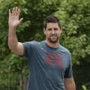Baltimore Ravens tight end Dennis Pitta waves to reporters as he reports to the team's practice facility in Owings Mills, Md., Wednesday, July 24, 2013, for NFL football training camp. (AP Photo/Patrick Semansky)