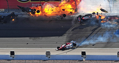 The car of Indy Car series driver Dan Wheldon (second car from left) catches fire as Wheldon and Will Power (12) crash into the wall at Las Vegas.