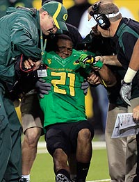 Oregon's LaMichael James is helped off the field after injuring his right arm.