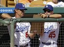 Los Angeles Dodgers manager Don Mattingly (8) looks over the lineup with bench coach Trey Hillman (45) during the fifth inning of a spring training baseball game against the Texas Rangers on Friday, March 16, 2012, in Glendale, Ariz.