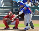 Chicago Cubs ' Darwin Barney triples in front of Cincinnati Reds catcher Corky Miller in the seventh inning of a spring training baseball game Tuesday, March 27, 2012, in Goodyear, Ariz. The Cubs won 7-4.