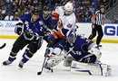 Tampa Bay Lightning goalie Dwayne Roloson , right, makes a save on New York Islanders ' Matt Moulson as he is defended by Lightning's Eric Brewer (2) during the third period of an NHL hockey game, Saturday, March 24, 2012, in Tampa, Fla. The Lightning won 4-3.