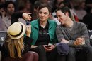 Actress Kaley Cuoco, left, takes a photo of actor Jim Parsons,center, and Todd Spiewak, right, as they sit courtside at the NBA basketball game between the Portland Trail Blazers and Los Angeles Lakers Friday, March 23, 2012, in Los Angeles.