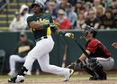 Oakland Athletics ' Yoenis Cespedes , left, pops out against the Arizona Diamondbacks during the third inning of a spring training baseball game, Monday, March 19, 2012, in Phoenix.