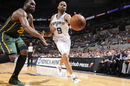 SAN ANTONIO, TX - APRIL 8:  Tony Parker #9 of the San Antonio Spurs and Al Jefferson #25 of the Utah Jazz reach for the ball during the game at the AT&T Center on April 8, 2012 in San Antonio, Texas.