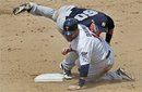 New York Yankees second baseman Jayson Nix lands on Minnesota Twins Ryan Doumit after turning a double play in the second inning of a spring training baseball game in Fort Myers, Fla., Sunday, March 11, 2012.