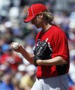 Cincinnati Reds starting pitcher Bronson Arroyo stares at the ball after giving up a home run to Chicago Cubs ' Alfonso Soriano during the second inning of a spring training baseball game in Mesa, Ariz., Monday, March 12, 2012.