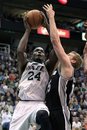 Utah Jazz forward Paul Millsap (24) attempts a shot while defended by San Antonio Spurs forward Matt Bonner , right, during the second half on a NBA basketball game, Monday, Feb. 20, 2012, in Salt Lake City. The Spurs won 106-102.