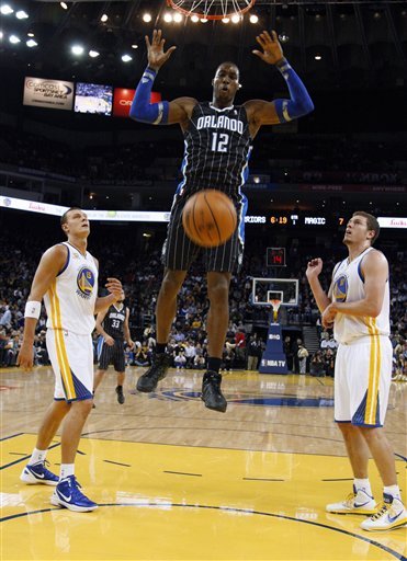 Orlando Magic's Dwight Howard (12) Dunks Next To Golden State Warriors' Andris Biedrins (15), Of Latvia, And David Lee (