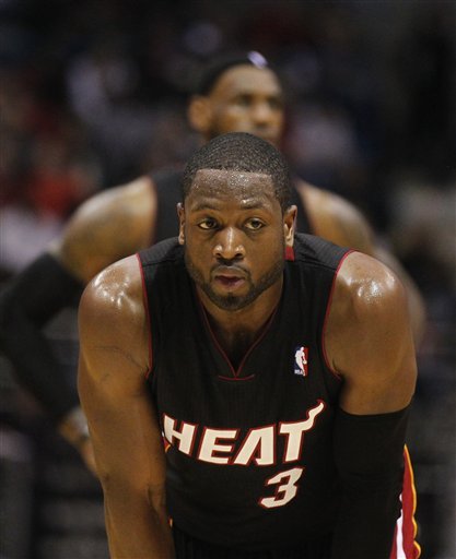 Miami Heat's Dwayne Wade (3) And Teammate LeBron James, Rear, Look On