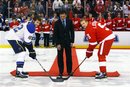 Former Detroit Red Wings defenseman Chris Chelios , center, drops a ceremonial first puck to St. Louis Blues center David Backes (42) and Detroit Red Wings defenseman Nicklas Lidstrom (5), of Sweden, in honor of being inducted into the United States Hockey Hall of Fame before an NHL hockey game in Detroit, Saturday, Dec. 31, 2011.