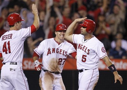 Los Angeles Angels' John Hester, Mike Trout, And Albert Pujols, From Left, Celebrate 