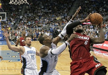 Miami Heat's LeBron James (6) Attempts A Shot Over Orlando Magic's Dwight Howard (12) As Hedo Turkoglu (15) Comes In To