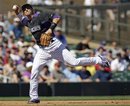 Colorado Rockies shortstop Troy Tulowitzki makes an off balance throw to out Chicago Cubs ' Blake DeWitt at first base during the third inning of a spring training baseball game on Thursday, March 15, 2012, in Scottsdale, Ariz.