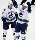 Vancouver Canucks left wing Daniel Sedin (22), of Sweden, celebrates his goal with defenseman Sami Salo (6), of Finland, against the Detroit Red Wings in the third period of an NHL hockey game in Detroit, Thursday, Feb. 23, 2012. Vancouver won 4-3 in a shootout.