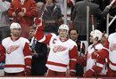 Detroit Red Wings defenseman Nicklas Lidstrom , center, of Sweden, acknowledges the crowd in the first period of an NHL hockey game against the Philadelphia Flyers in Detroit, Sunday, Feb. 12, 2012.  Lidstrom played in his 1,550th game, the most by an NHL player who spent his entire career with one team.