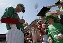 Philadelphia Phillies pitcher Roy Halladay , left, signs autographs for fans before a spring training baseball game against the Toronto Blue Jays at Brighthouse Field in Clearwater, Fla., Saturday, March 17, 2012.