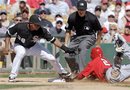 Los Angeles Angels ' Erick Aybar (2) beats the tag from Chicago White Sox third baseman Eduardo Escobar (38) to steal third during the fifth inning of a spring training baseball game on Wednesday, March 14, 2012, in Glendale, Ariz. Third base umpire Cory Blaser waits to make the call.