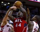 Atlanta Hawks forward Ivan Johnson (44) drives to the basket between Toronto Raptors forwards Linas Kleiza , left, and Ed Davis , and is fouled, during the second half of an NBA basketball game Tuesday, Jan. 31, 2012, in Toronto.