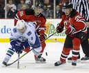 Vancouver Canucks ' Cody Hodgson battles for the puck with New Jersey Devils ' Petr Sykora (15) and Patrik Elias , right, of the Czech Republic, during the second period of an NHL hockey game Friday, Feb. 24, 2012, in Newark, N.J. The Canucks defeated the Devils 2-1.