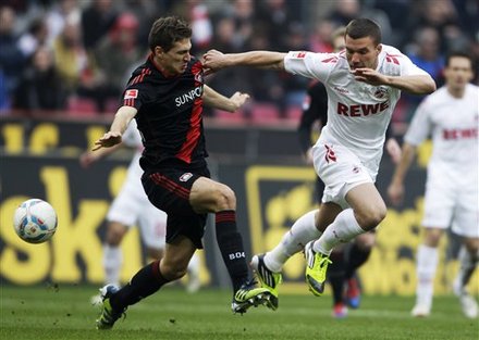 Leverkusen's Daniel Schwaab, Left, And Cologne's Lukas Podolski Challenge For The Ball