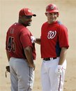 Washington Nationals ' Ryan Zimmerman , right, playfully punches Houston Astros first baseman Carlos Lee (45) after hitting a single in the fifth inning during a spring training baseball game in Viera, Fla., Thursday, March 8, 2012.