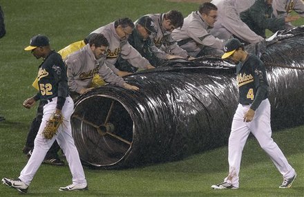 Oakland Athletics' Yoenis Cespedes (52) And Coco Crisp (4) Walk Off The Field As Groundskeepers Unravel A Tarp For The