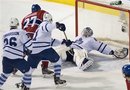 Toronto Maple Leafs goaltender Jonas Gustavsson , right, makes a save against Montreal Canadiens ' Rene Bourke (27) as Maple Leafs' Jake Gardiner and Carl Gunnarsson close in during second period NHL hockey game action in Montreal, on Saturday, March 3, 2012.