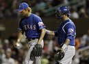 Texas Rangers starting pitcher Yu Darvish , left, gets a visit to the mound from catcher Mike Napoli against the Colorado Rockies during the sixth inning of a spring training baseball game Friday, March 30, 2012 in Scottsdale, Ariz.