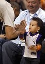 Two-year-old Henry Knight, right, gives a hig-five to NBA referee Dan Crawford, left, after Crawford presented him with a t-shirt during a tmeout between the New Orleans Hornets and the Phoenix Suns in the fourth quarter of an NBA basketball game Sunday, April 1, 2012, in Phoenix. The Suns won 92-75.