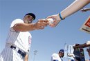 Chicago Cubs left fielder Reed Johnson hands an autographed baseball to a young fan prior to playing the Los Angeles Angels in a spring training baseball game on Saturday, March 31, 2012, in Mesa, Ariz.