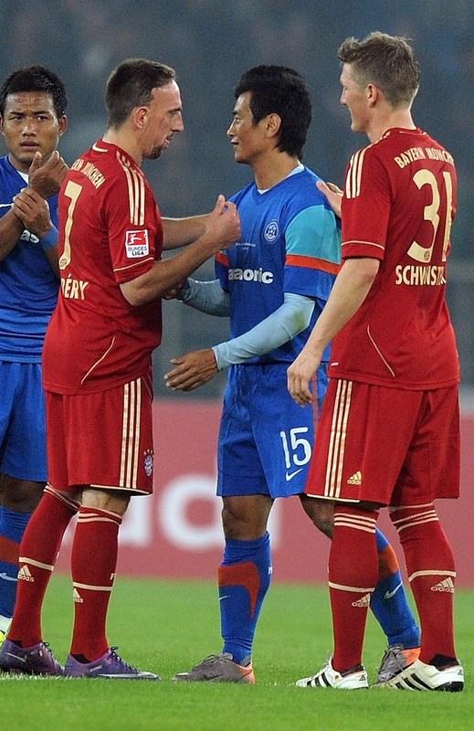 Frank Ribery (L) And Bastian Schweinsteiger (R) Of Bayern Munich Talk With India's Baichung Bhutia (C) As He Walks Off