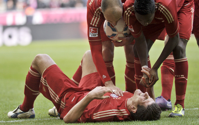 Bayern Munich's German Striker Mario Gomez Is Comforted By Teammates As He Lies Injured On The Pitch RESTRICTIONS /