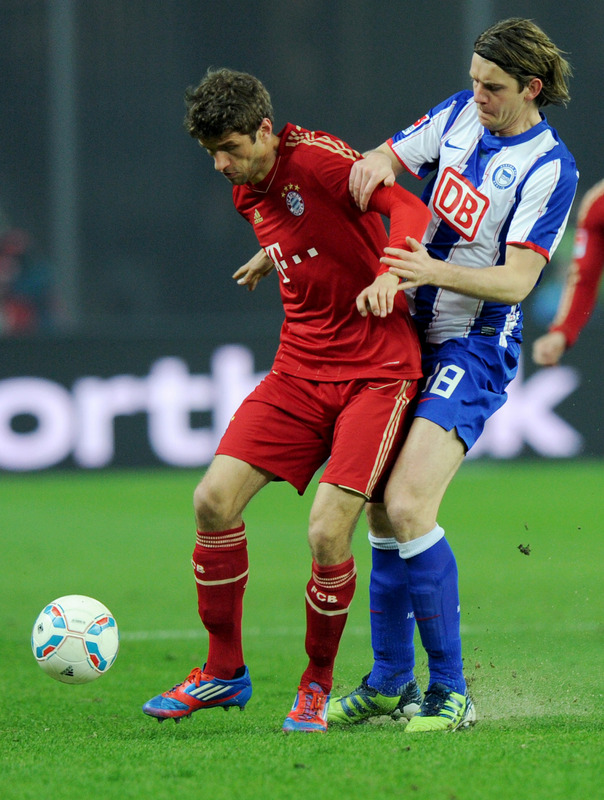 Bayern Munich's Midfielder Thomas Mueller (L) And Hertha Berlin's Midfielder Peter Niemeyer Vie For The Ball 