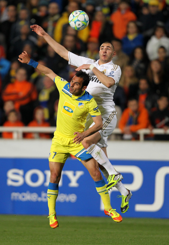 APOEL's Cypriot Defender Savvas Poursaitides (L) Vies For The Ball Against Real Madrid's French Forward Karim Benzema