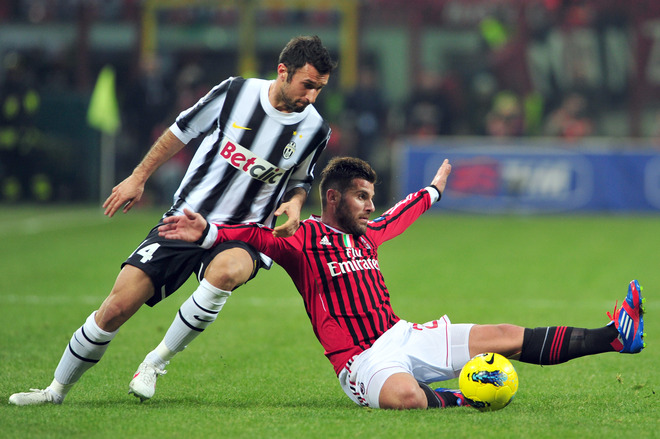 AC Milan's Defender Antonio Nocerino (R) Fights For The Ball With Juventus Forward Mirko Vucinic On February 25, 2012