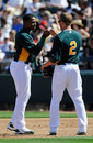 PHOENIX, AZ - MARCH 10: Yoenis Cespedes #52 of the Oakland Athletics is congratulated by Cliff Pennington #2 after his first single of the spring during the second inning of a spring training baseball game against the Cincinnati Reds at the Phoenix Municipal Stadium on March 10, 2012 in Phoenix, Arizona. (Photo by Kevork Djansezian/Getty Images)