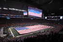 ARLINGTON, TX - JANUARY 06:  An American flag covers the field as The Band Perry performs the national anthem before a game between the Arkansas Razorbacks and the Kansas State Wildcats during the Cotton Bowl at Cowboys Stadium on January 6, 2012 in Arlington, Texas.  (Photo by Ronald Martinez/Getty Images)