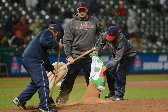  Members Of The Cleveland Indians' Grounds Crew Try To Prepare The Pitchers Mound For The Seventh Inning Of The Game