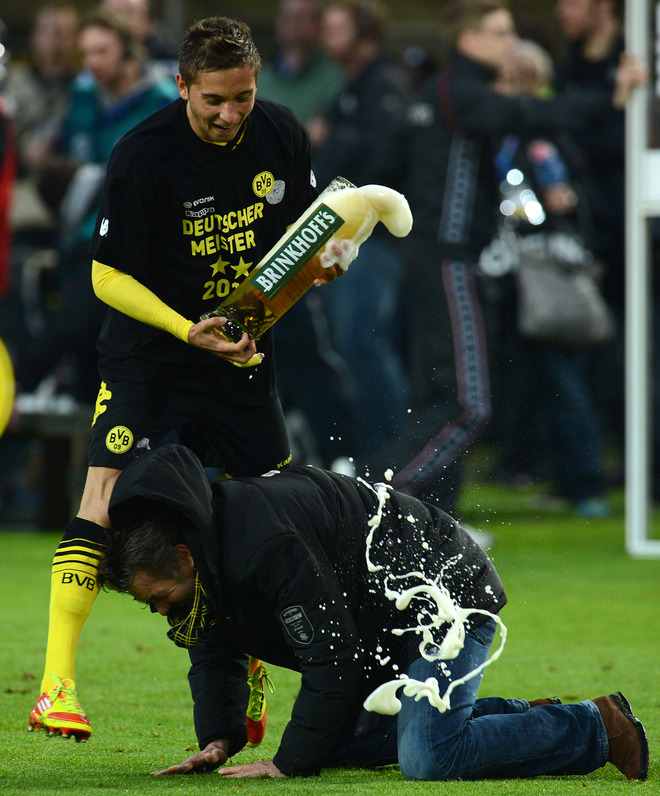 Dortmund's Midfielder Moritz Leitner Pours Beer On Dortmund's Manager Michael Zorc AFP PHOTO / PATRIK STOLLARZ