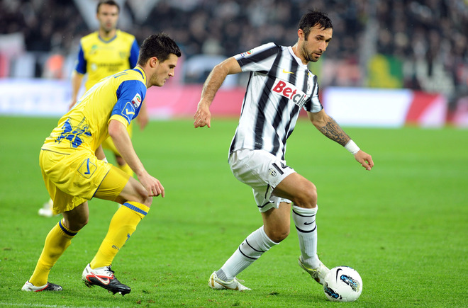 Juventus Forward Mirko Vucinic (R) Of Montenegro Controls The Ball In Front Of Chievo Defender Marco Andreollis On