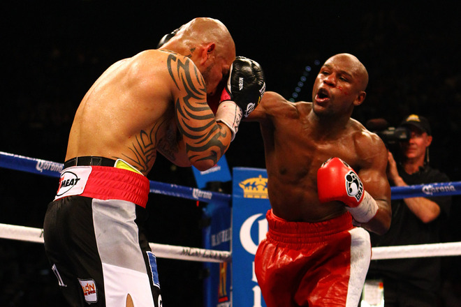   (R-L) Floyd Mayweather Jr.throws A Right To The Face Of Miguel Cotto