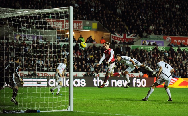 Arsenal's Welsh Midfielder Aaron Ramsey (3rd R) Heads The Ball At Goal Under A Challenge From Swansea City's Ashley