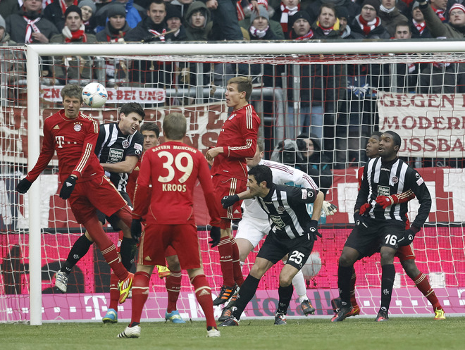 Bayern Munich's German Striker Thomas Mueller (L) Clears A Corner Kick RESTRICTIONS / EMBARGO - DFL LIMITS THE USE OF