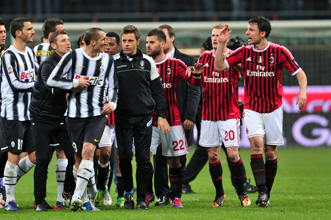 Juventus' Defender Giorgio Chiellini (L) Talks With AC Milan's Dutch Defender Mark Van Bommel (R) On February 25, 2012