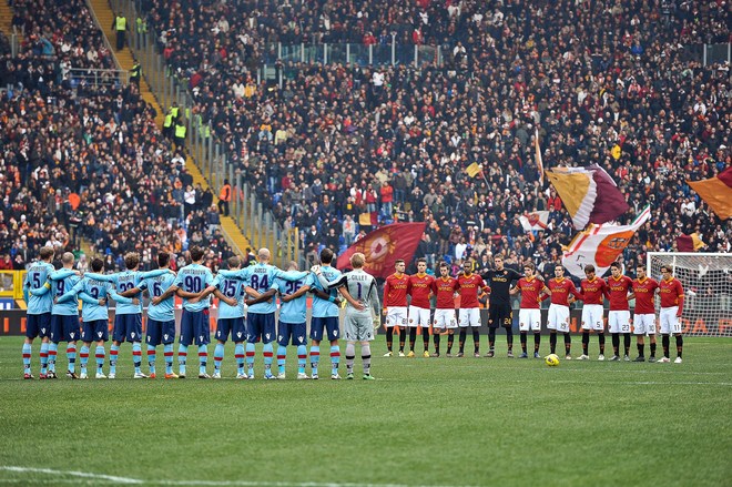 AS Roma's (R) And FC Bologna Players Stand Silent For A Minute In Memory Of Former Italian Presidente Oscar Luigi